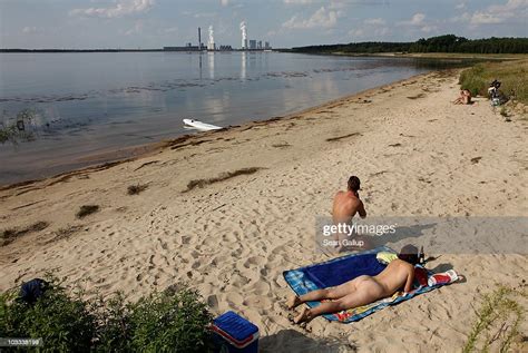 Bathers Enjoy The Beach At Baerwalder See Lake As Exhaust Rises From