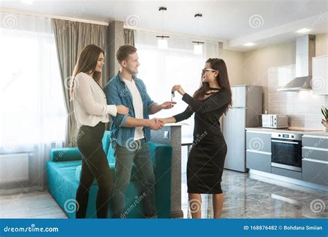 Attractive Woman Realtor Property Manager Shaking Hands With Clients Couple Man And Woman At