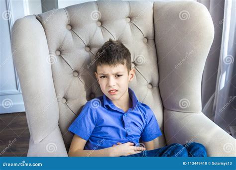 The Disgruntled Teen Boy Sitting At Home Stock Photo Image Of