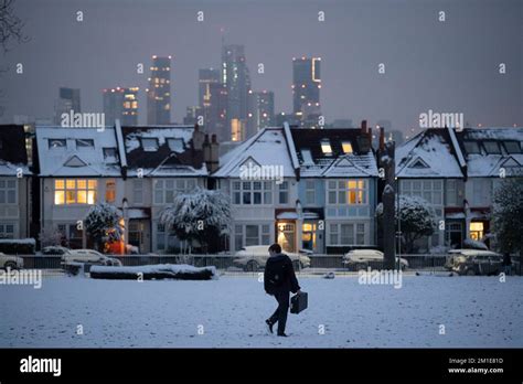 A commuter walks past residential properties after low temperatures and