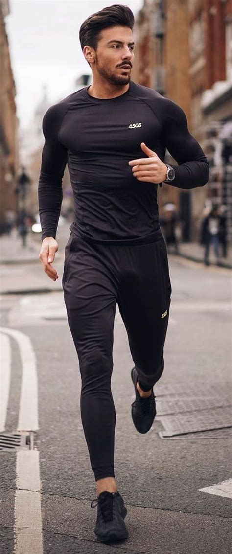 A Man Running Down The Street In His Black Sports Suit With No Shoes On