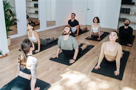 Relaxed Group Of People Practicing Yoga Doing Upward Facing Dog Stock