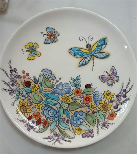 A Plate With Flowers And Butterflies Painted On It