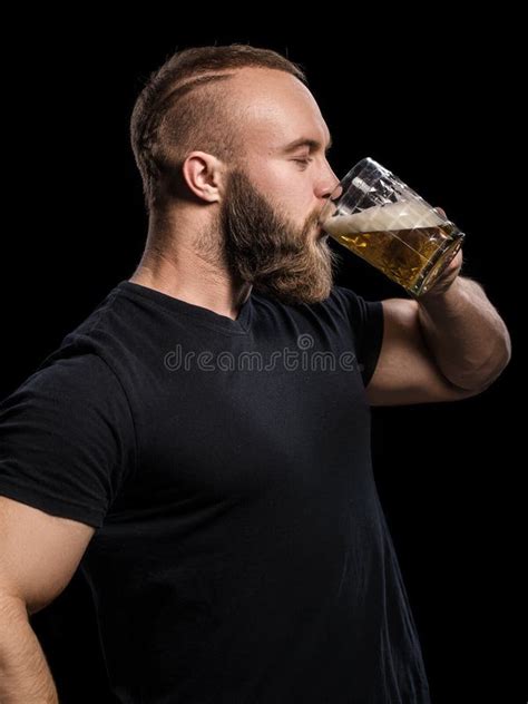 Bearded Man Drinking Beer From A Beer Mug Over Black Background Stock