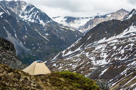 Tan Tent On A Narrow Ledge Overlooking Broad Valley And Distance