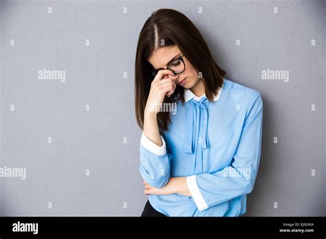 Portrait Of A Pensive Businesswoman Standing Over Gray Background Wearing In Blue Shirt And