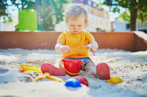 Adorable Little Girl Having Fun On Playground In Sandpit Stock Image
