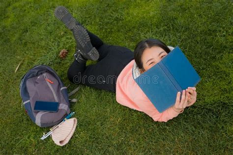 Young Asian Woman Enjoying Novel On Grass Lifestyle Portrait Of Young