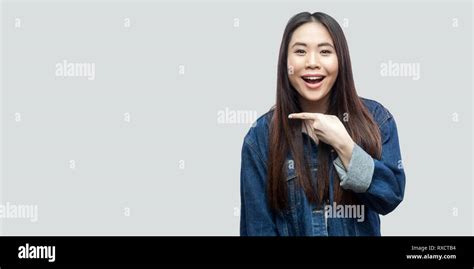 Portrait Of Excited Beautiful Brunette Asian Young Woman In Casual Blue Denim Jacket With Makeup