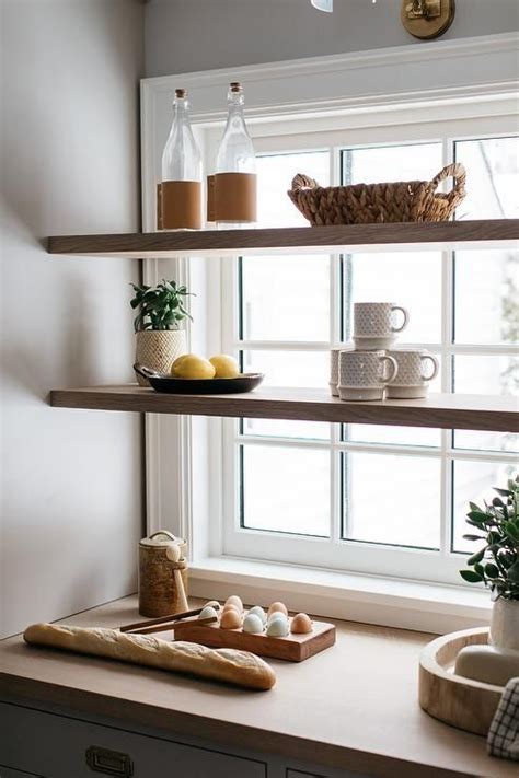 Stacked Wood Floating Shelves Are Mounted In Front Of A Window In A