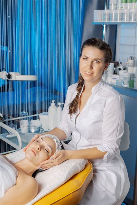 Professional Beautician Makes A Facial Massage To A Woman Stock Photo