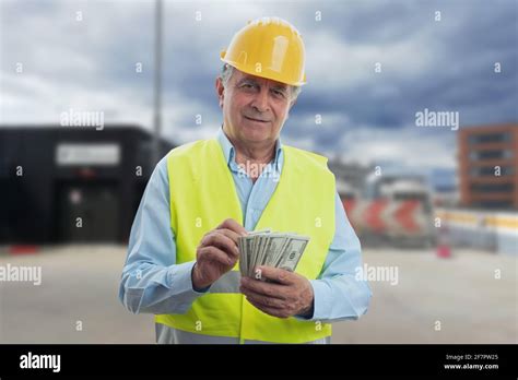 Elderly male construction worker wearing yellow protective hardhat and