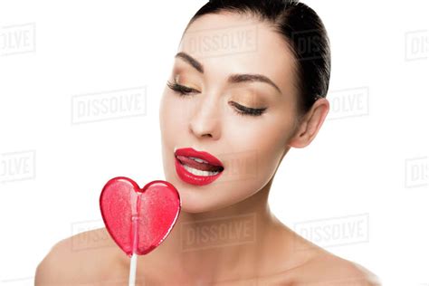 Seductive Woman With Red Heart Shaped Lollipop Licking Her Lips
