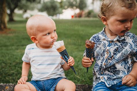 Young White Toddler And Baby Eating Ice Cream In The Summer Stock Photo