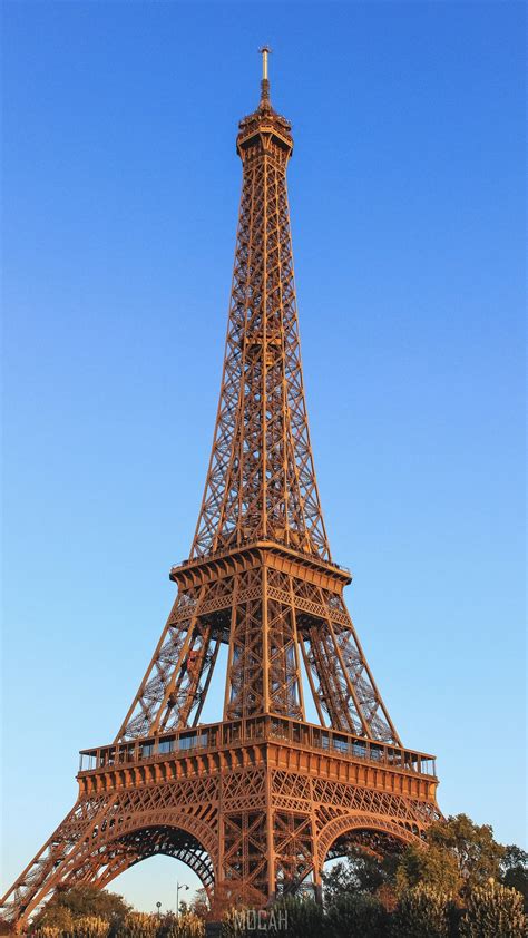 A Full View Of The Eiffel Tower In Paris With Clear Blue Skies Behind