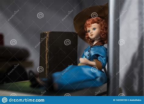Portrait Of Porcelain Doll With Red Hair Dressed In Blue Stock Photo