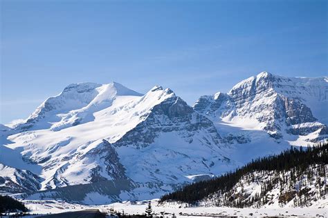 Snow Capped Mountains With A Blue Sunny Photograph By Sundown001 Pixels