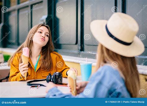 two lesbian girls enjoy a relaxed chat while having ice creams outdoors stock image image of