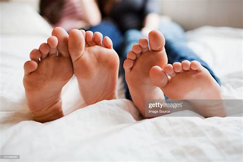 Two Teenage Girls Lying On Bed Barefoot Photo Getty Images
