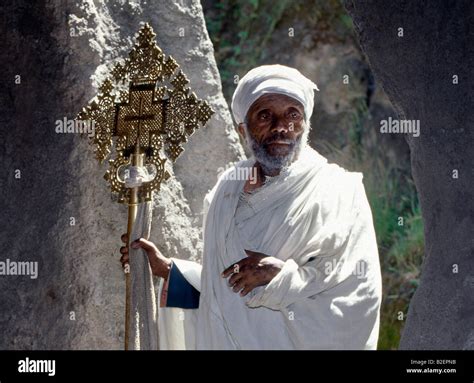 An Old Ethiopian Orthodox Priest Holds A Large Brass Coptic Cross At