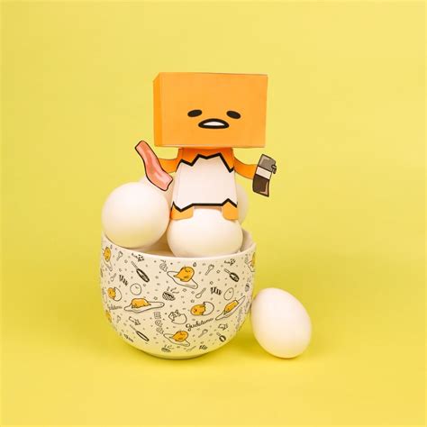 An Egg Carton With Two Eggs In It And A Paper Toy Standing On Top