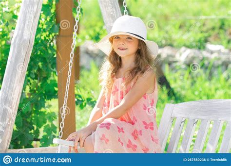 Cute Little Girl On A Swing Smiling Child Playing Outdoors In Summer