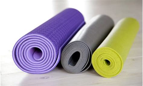 Yoga Mats Lined Up On The Floor With One Rolled Up And Another Rolled