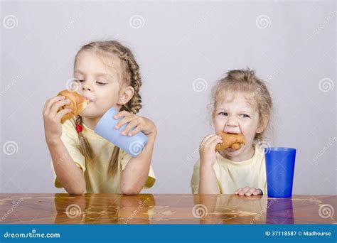 Two Children Eat A Muffin At The Table Stock Image Image Of Table