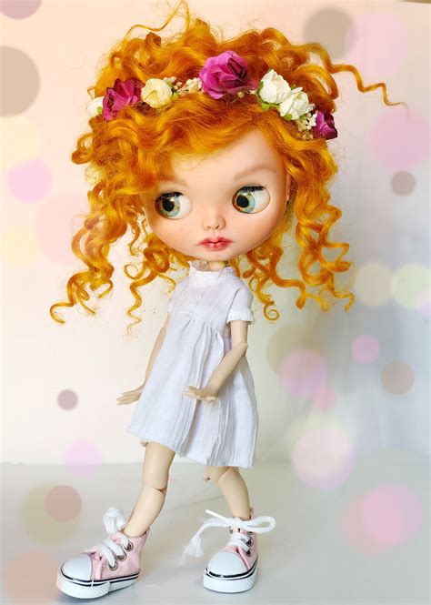 A Doll With Red Hair And Flowers In Her Hair