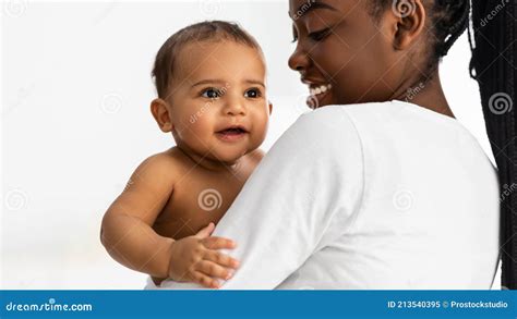 African American Mom Holding Her Cute Infant At Home Stock Image