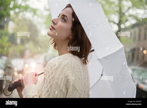 Caucasian Woman Holding Umbrella Looking Up Stock Photo Alamy
