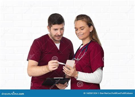 Medical Team Of Doctor And Nurse Looking At Phone Consulting Patient