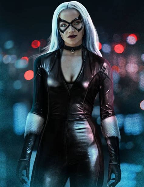A Woman In Black Catsuits And Glasses Standing On A City Street At Night