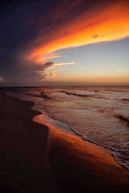 Premium Photo View Of The Sandy Beach During A Dramatic Cloudy Sunset