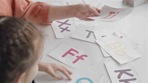 Top View Slowmo Shot Of Little Girl Using Cards With Colorful Letters