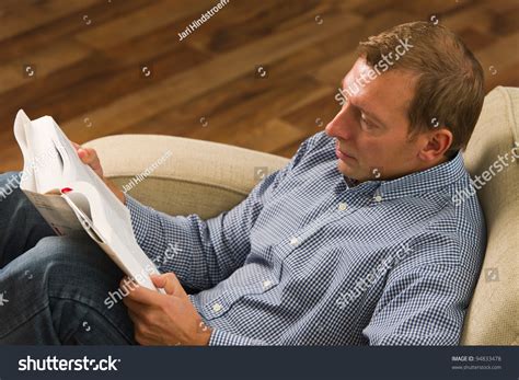 Man Sitting On The Armchair And Reading The Book Stock Photo 94833478
