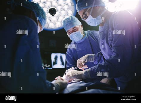 Medical Team Performing Surgical Procedure In Operating Theater