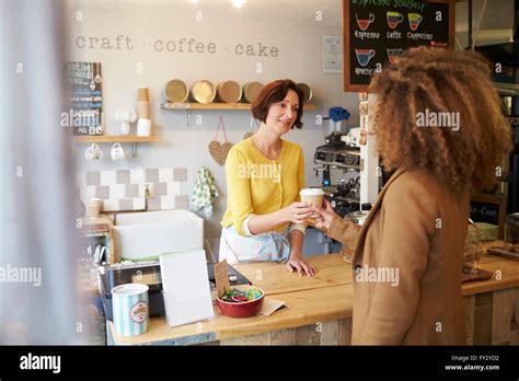 Owner Of Coffee Shop Serving Female Customer Stock Photo Alamy