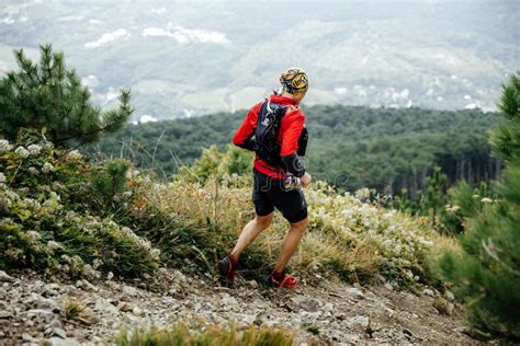 Male Athlete Marathon Runner Running With Mountains Along Trail