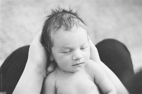 Black And White Portrait Of A Newborn Baby Held In His Father S Hands