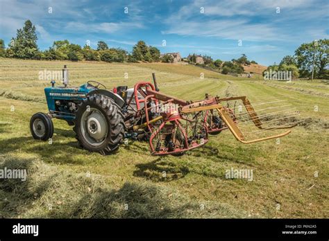 Uk Farming A Vintage Ford 3000 Tractor And Hayrake In A Field Of