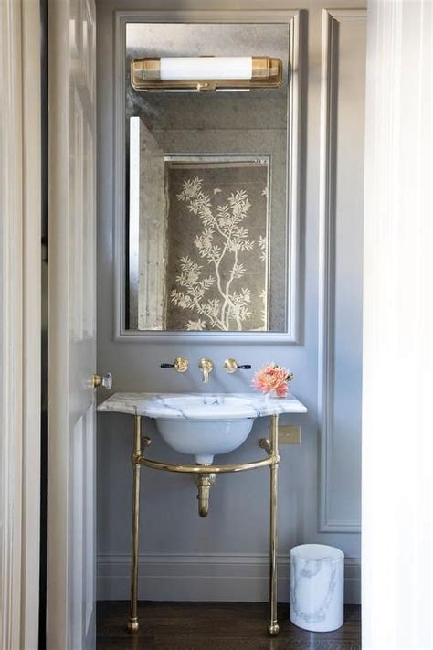 French Powder Room With A Marble And Brass Sink Vanity On A Gray Wall