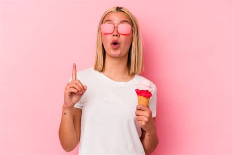 Premium Photo Young Venezuelan Woman Eating An Ice Cream Isolated On Pink Wall Pointing Upside