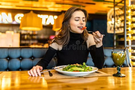 Young Woman Eating Healthy Food Sitting In The Beautiful Interior Stock