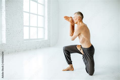 Senior athletic man with naked torso practising yoga poses in the white studio Stock 写真 Adobe