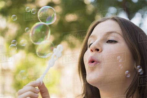 Close Up Of Caucasian Woman Blowing Bubbles Outdoors Stock Photo