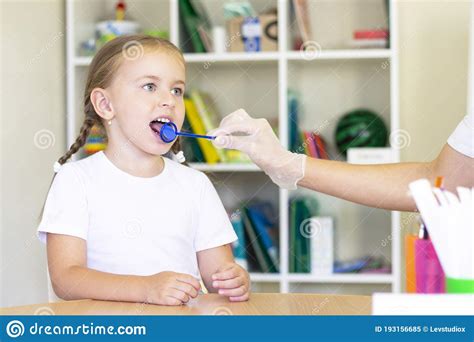 Speech Therapy Massage Of The Girl`s Tongue A Speech Therapist Makes A Tongue Massage Stock