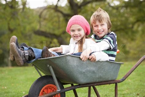 Boy And Girl Sitting In Wheelbarrow Stock Image Colourbox