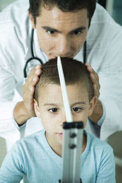 Doctor Measuring Boy During Check Up Stock Photo Dissolve