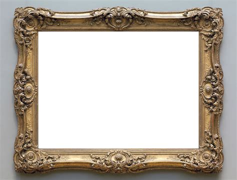 An Ornate Gold Framed Mirror Hanging On The Wall With A White